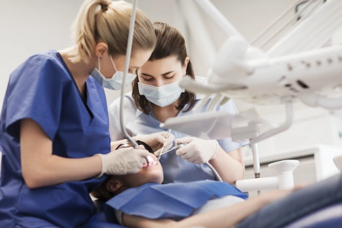 dental assistant helping dentist with patient oral cleaning